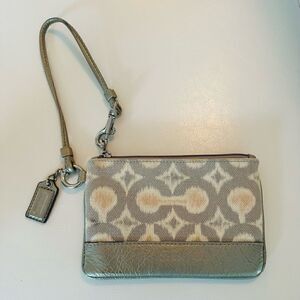Coach cream canvas wristlet with leather trim.